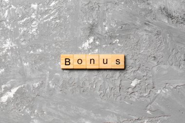 Tahta blokta bonus kelime yazıyor. Masada bonus metin, konsept.
