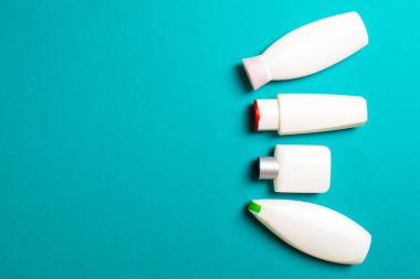 Renkli arkaplanda izole edilmiş Beyaz Kozmetik konteynırları seti, fotokopi alanı ile üst görünüm. Senin için bir grup plastik kaplar ve boş bir yer tasarladın..