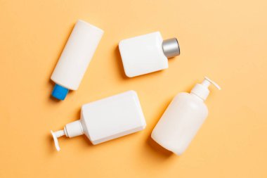 Renkli arkaplanda izole edilmiş Beyaz Kozmetik konteynırları seti, fotokopi alanı ile üst görünüm. Senin için bir grup plastik kaplar ve boş bir yer tasarladın..