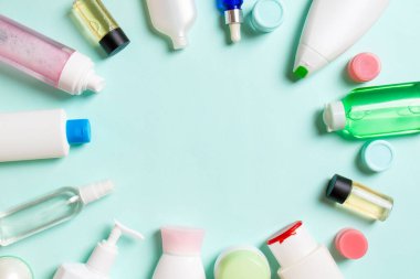 Plastik vücut bakım şişesi çerçevesi düz kompozisyonda renkli arka plan boşluğunda sizin tasarımınız için kozmetik ürünler sergileniyordu. Beyaz Kozmetik kapları kümesi, kopya alanı ile üst görünüm.