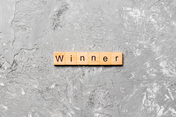 木のブロックに書かれた勝者の単語 あなたのデザイン コンセプトのセメントテーブルの勝者のテキスト — ストック写真