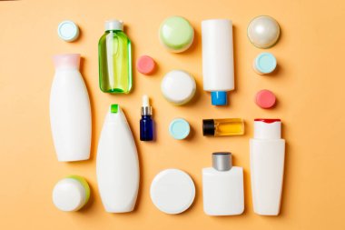 Plastik gövde bakımı şişesi düz kompozisyonu ve renkli arka plan boşluğuna kozmetik ürünler dizayn edilmişti. Beyaz Kozmetik kapları kümesi, kopya alanı ile üst görünüm.