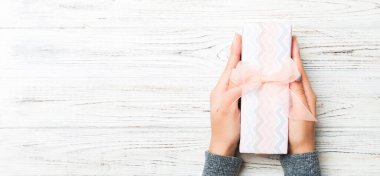 Beyaz kırsal ahşap arka planda kadın eli var. Noel tatili ya da diğer tatiller için şenlikli bir zemin. Fotokopi alanı ile düz serili biçim üst görünümü.