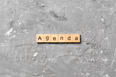 Tahta blokta yazan AGENDA kelimesi. AGENDA metin çimento tablo üzerinde desing için, konsept.