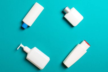 Renkli arkaplanda izole edilmiş Beyaz Kozmetik konteynırları seti, fotokopi alanı ile üst görünüm. Senin için bir grup plastik kaplar ve boş bir yer tasarladın..