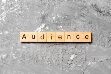 Tahta bloğa yazılmış bir kelime. Deksing, konsept için beton masa üzerinde AUDIENCE metin.