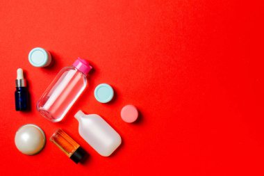 Kozmetik SPA marka modeli, fotokopi alanı olan üst görünüm. Renkli arka planda duran krema tüpleri ve kavanozları..