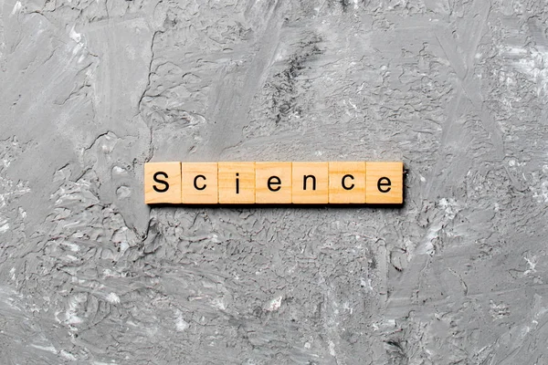 在木块上写的科学字 科学课本在水泥桌上为您的设计 — 图库照片