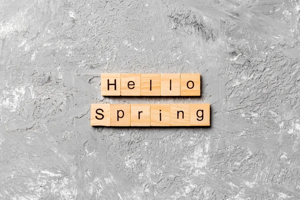 hello Spring word written on wood block. hello Spring text on cement table for your desing, concept.