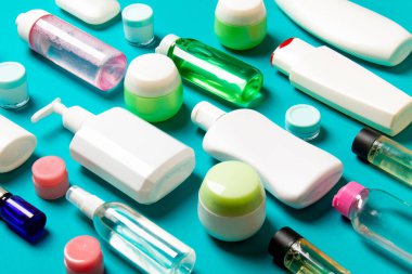 Renkli arka plandaki kozmetik ürünleri için farklı boyutlarda şişeler ve kavanozlar. Fotokopi alanı ile yüz ve vücut bakımı kavramı.