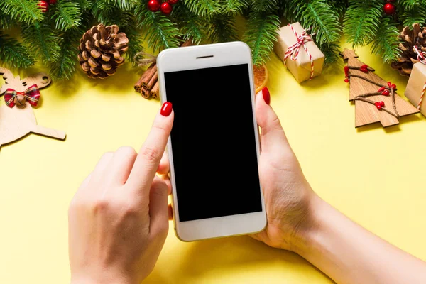 Telefon Felső Nézete Női Kézben Ünnepi Sárga Háttérrel Karácsonyi Dekoráció — Stock Fotó