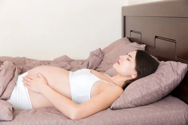 Joven Mujer Embarazada Bonita Con Dolor Sentada Cama Dormitorio Preparándose —  Fotos de Stock