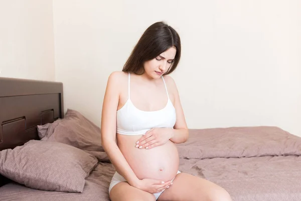 Joven Mujer Embarazada Bonita Con Dolor Sentada Cama Dormitorio Preparándose — Foto de Stock