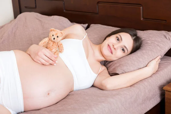 Närbild Gravid Kvinna Med Nalle Liggande Sängen — Stockfoto