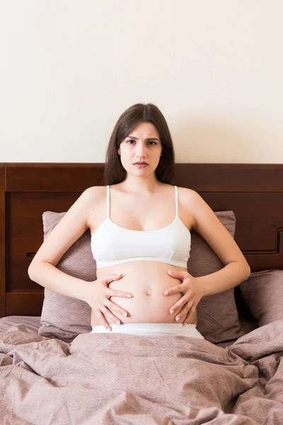 Mladá Krásná Těhotná Žena Bolestech Sedí Posteli Ložnici Připravuje Porod — Stock fotografie