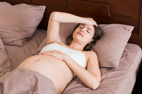 Genç Güzel Hamile Bir Kadın Evde Yatağında Baş Ağrısı Çekiyor — Stok fotoğraf
