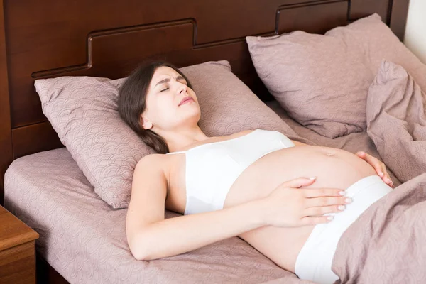 Jovem Mulher Grávida Bonita Com Dor Sentada Cama Quarto Preparando — Fotografia de Stock