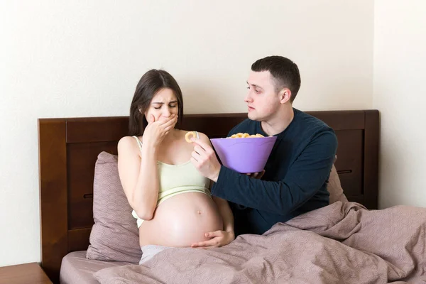 남편은 아내에게 과자를 주지만 아내는 거부하고 아프기 때문에 행동을 임신중에 — 스톡 사진