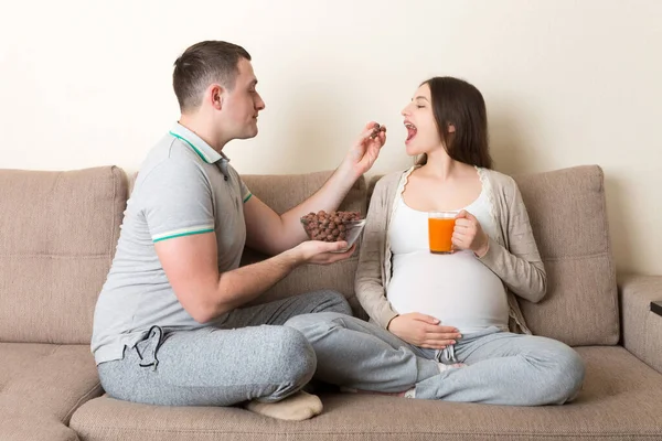 Gelukkig Man Voedt Zijn Zwangere Vrouw Met Chocolade Cornflakes Ballen — Stockfoto