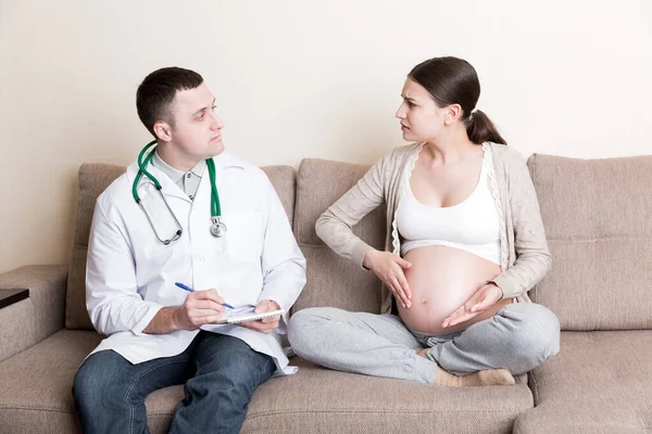 Lekarz Zapisuje Skargi Ciężarnej Kobiety Notesu Problemy Zdrowotne Podczas Ciąży — Zdjęcie stockowe