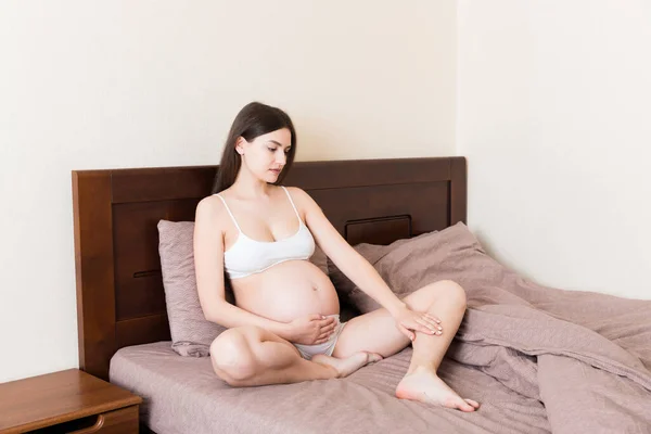 Bonita Mulher Grávida Mãos Massagem Perna Sentado Cama — Fotografia de Stock