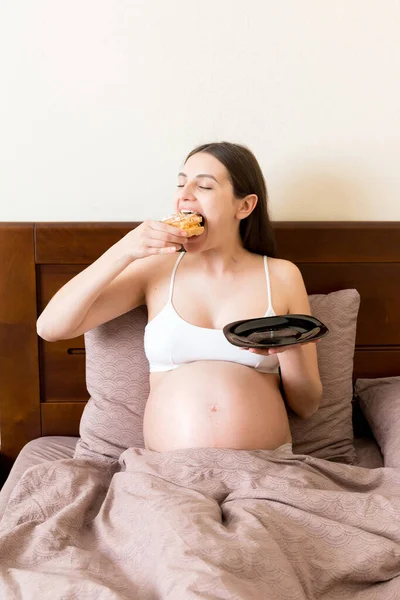 배가고 임산부는 집에서 침대에 머무는 맛있는 디저트를 임신중에 음식을 즐기는 — 스톡 사진