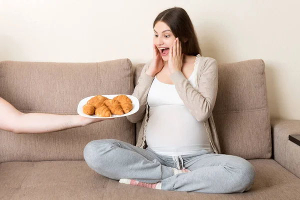 Marido Oferece Sua Esposa Grávida Croissants Relaxar Sofá Casa Futuro — Fotografia de Stock