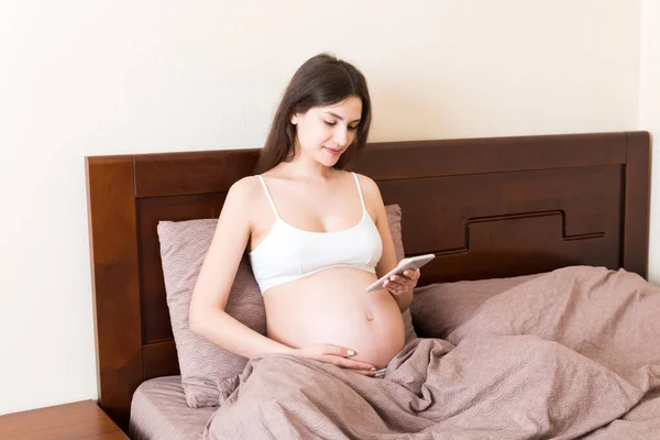 Ragazza Incinta Caucasica Utilizzando Cellulare Riposo Sul Letto Casa — Foto Stock