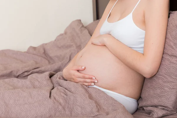 Junge Hübsche Schwangere Frau Sitzt Unter Schmerzen Auf Dem Bett — Stockfoto