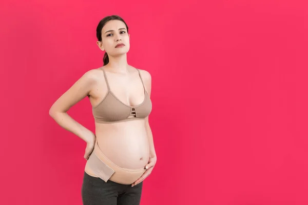 Retrato Mujer Embarazada Vendaje Contra Dolor Espalda Fondo Rosa Con —  Fotos de Stock