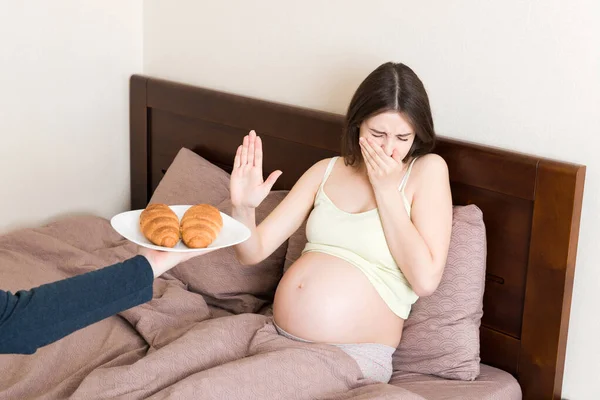 침대에서 휴식을 취하는 임신부는 크로와 제스처를 멈춘다 엄마가 페이스트리먹기를 예상하면서요 — 스톡 사진