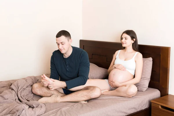Feliz Familia Embarazada Esposo Masajeando Las Piernas Esposa Embarazada Sentados — Foto de Stock