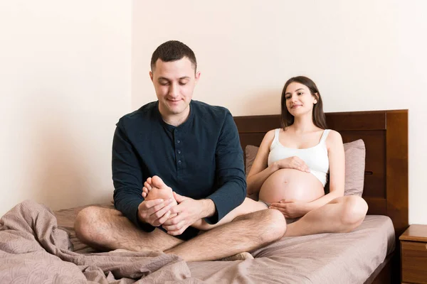 Gelukkige Zwangere Familie Man Masseren Zijn Zwangere Vrouw Benen Samen — Stockfoto