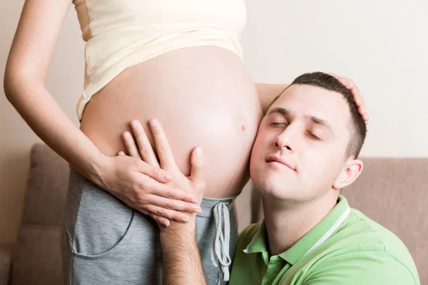 Joven Barbudo Poniendo Oreja Cerca Sus Esposas Embarazadas Abdomen Escuchándolo — Foto de Stock