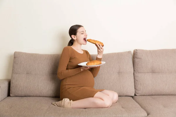 Une Femme Enceinte Assise Sur Canapé Mange Des Croissants Dans — Photo