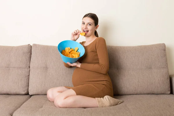 Pregnant Woman Sitting Sofa Enjoys Eating Potato Chips Bowl Home — Stock Photo, Image