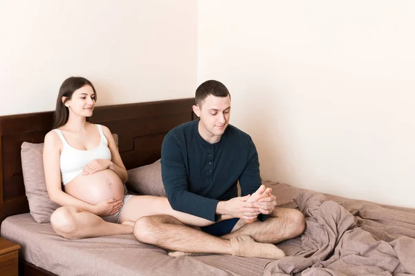 Feliz Familia Embarazada Esposo Masajeando Las Piernas Esposa Embarazada Sentados — Foto de Stock