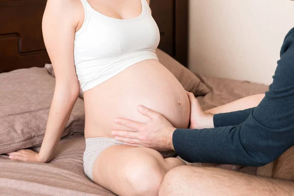 Mujer Embarazada Con Marido Sentado Cama Cogido Mano Vientre Casa — Foto de Stock