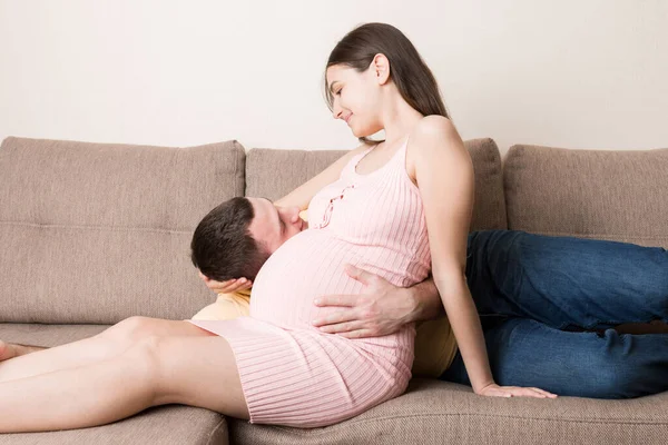 Echtgenoot Luisteren Naar Buik Van Zijn Zwangere Vrouw Bank Thuis — Stockfoto