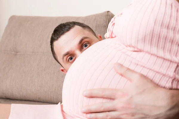 Σύζυγος Ακούει Την Κοιλιά Της Εγκύου Γυναίκας Του Στον Καναπέ — Φωτογραφία Αρχείου