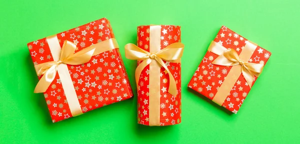 Draufsicht Frau Hält Weihnachtsgeschenkschachtel Mit Goldschleife Auf Grünem Hintergrund — Stockfoto