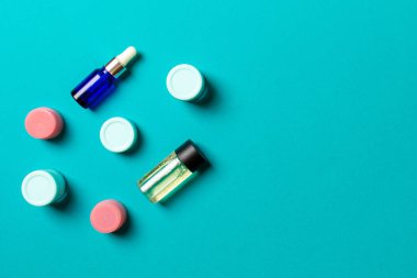 Kozmetik SPA marka modeli, fotokopi alanı olan üst görünüm. Renkli arka planda duran krema tüpleri ve kavanozları..