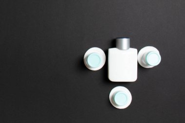 Renkli arka planda seyahat etmek için bir grup küçük şişe. Fikirlerin için uzayı kopyala. Kozmetik ürünlerin düz bileşimi. Pamuklu krema kaplarının üst görüntüsü.