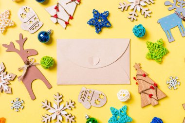 Sarı arka planda yeni yıl oyuncakları ve süslemeleri olan el sanatları zarfı manzarası. Noel zamanı konsepti.