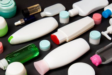 Plastik gövde bakımı şişesi düz kompozisyonu ve renkli arka plan boşluğuna kozmetik ürünler dizayn edilmişti. Beyaz Kozmetik kapları kümesi, kopya alanı ile üst görünüm.