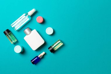 Kozmetik SPA marka modeli, fotokopi alanı olan üst görünüm. Renkli arka planda duran krema tüpleri ve kavanozları..