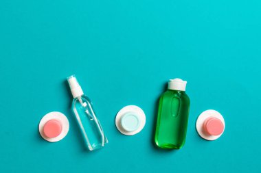 Renkli arka planda seyahat etmek için bir grup küçük şişe. Fikirlerin için uzayı kopyala. Kozmetik ürünlerin düz bileşimi. Pamuklu krema kaplarının üst görüntüsü.