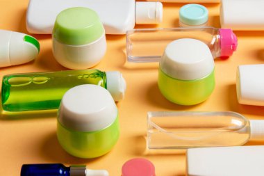 Plastik gövde bakımı şişesi düz kompozisyonu ve renkli arka plan boşluğuna kozmetik ürünler dizayn edilmişti. Beyaz Kozmetik kapları kümesi, kopya alanı ile üst görünüm.