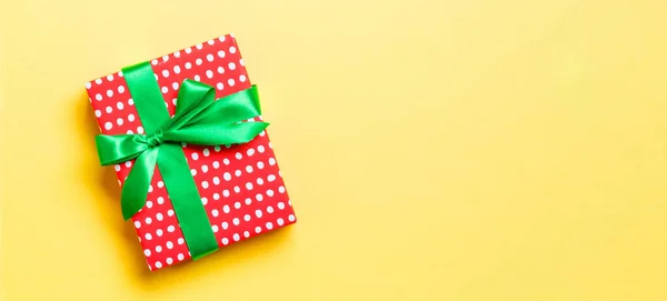 包装圣诞节或其他节日手工纸制礼物 绿色缎带 黄色背景 礼品盒 彩色桌上的礼品装饰 顶部有复印空间 — 图库照片