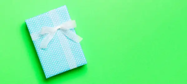 用绿色背景的白色缎带包装圣诞礼物或其他手工制作的节日礼物 礼品盒 彩色桌上的礼品装饰 顶部有复印空间 — 图库照片